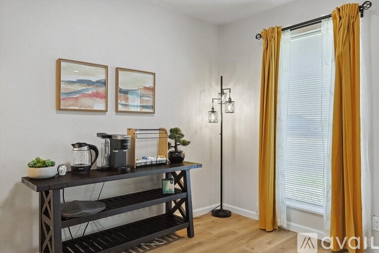 A black table with a plant and a coffee maker on it.