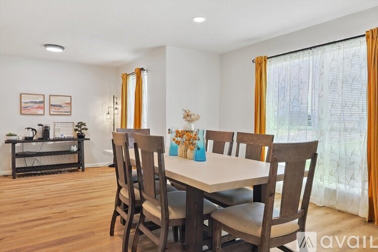 A dining room with a table and chairs.