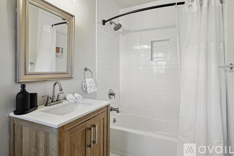 A bathroom with a white sink and a mirror above it.
