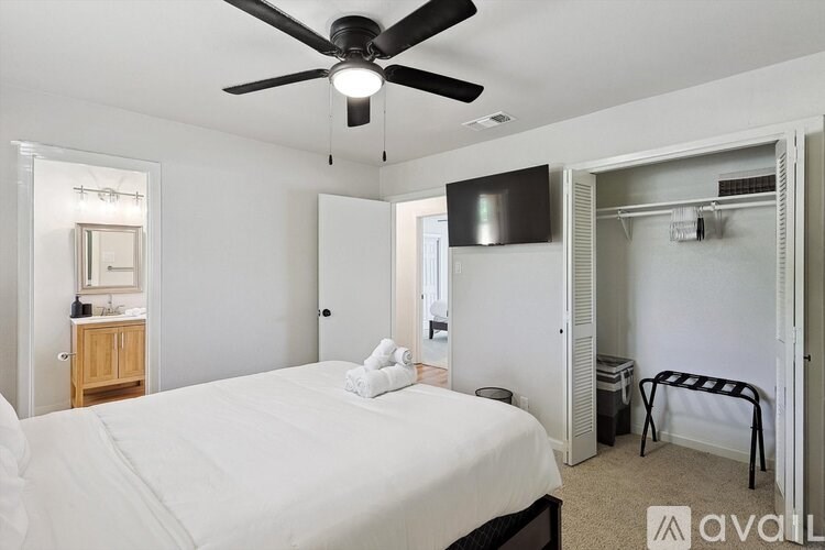 A bedroom with a large bed and a ceiling fan.