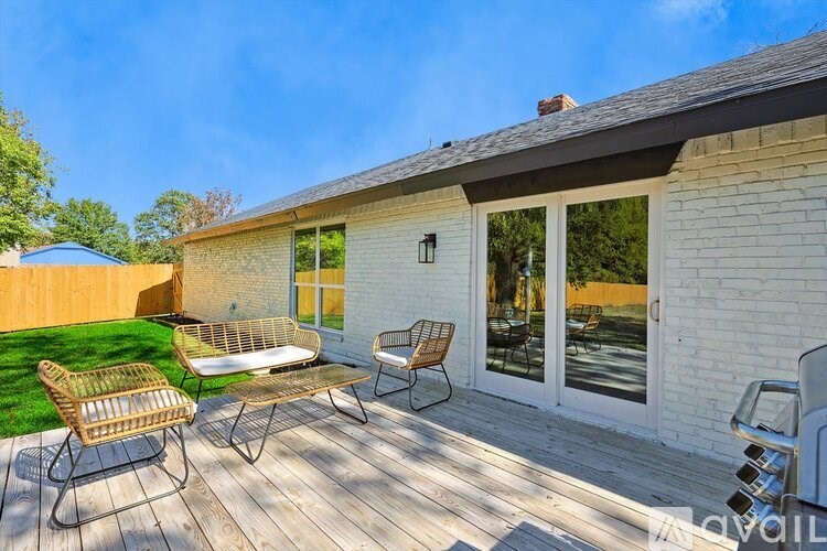 A patio with a table and chairs is on a wooden deck.