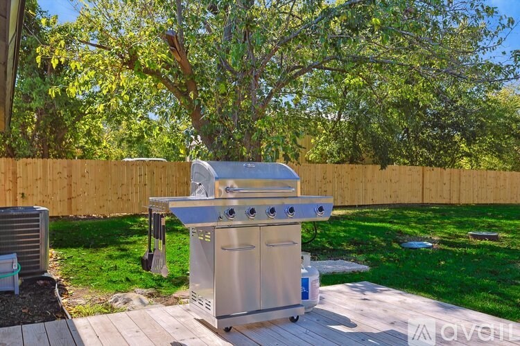 A stainless steel outdoor kitchen set up on a wooden deck.