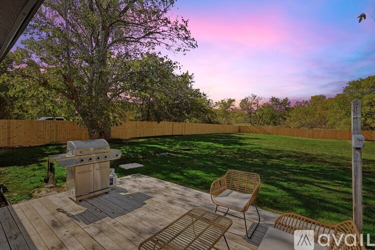 A backyard with a grill and a chair.