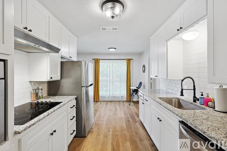 A kitchen with white cabinets and a granite countertop.