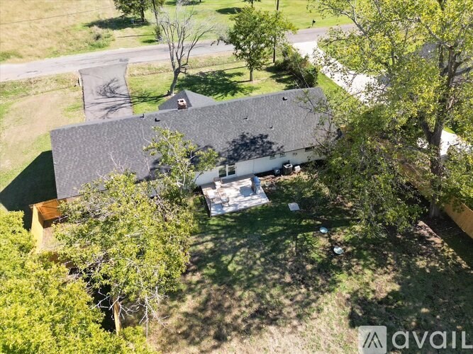 A house with a grey roof surrounded by trees.
