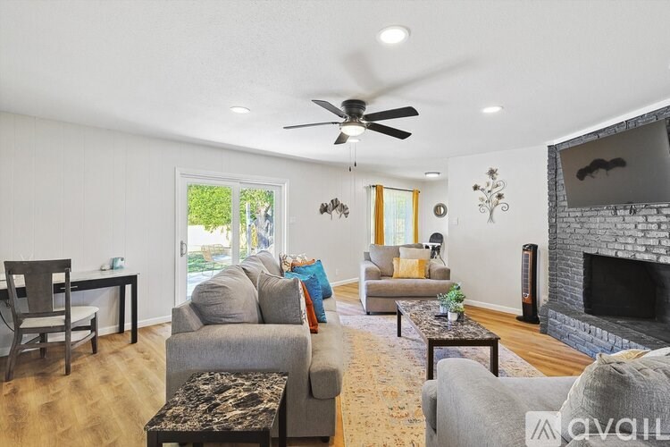 A living room with a grey couch and a fireplace.