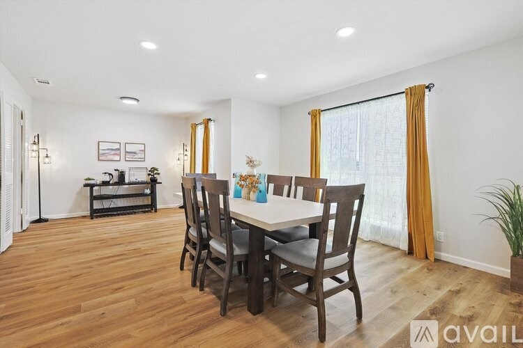 A dining room with a wooden table and chairs.
