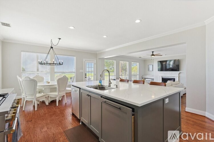 A modern kitchen with a center island and a dining area.