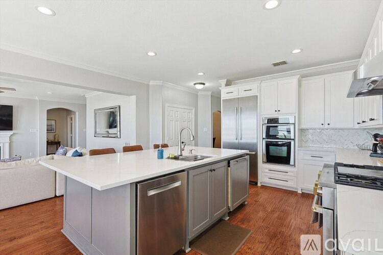 A modern kitchen with stainless steel appliances and white cabinetry.