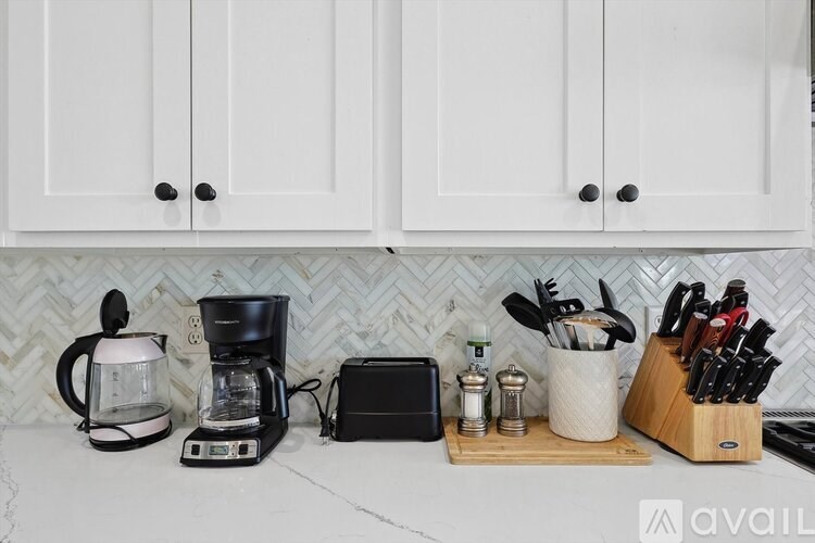 A kitchen counter with a coffee maker, a knife block, and a cutting board.