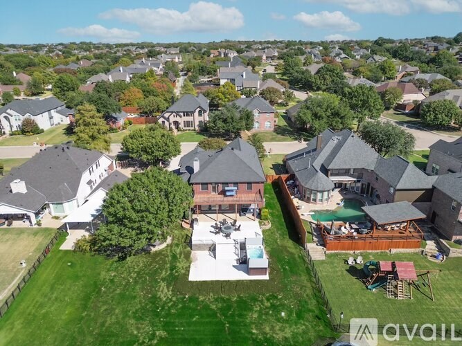 A bird's eye view of a suburban neighborhood with houses and lawns.