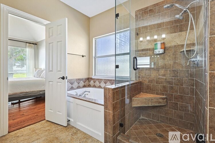 A bathroom with a walk-in shower and a window.