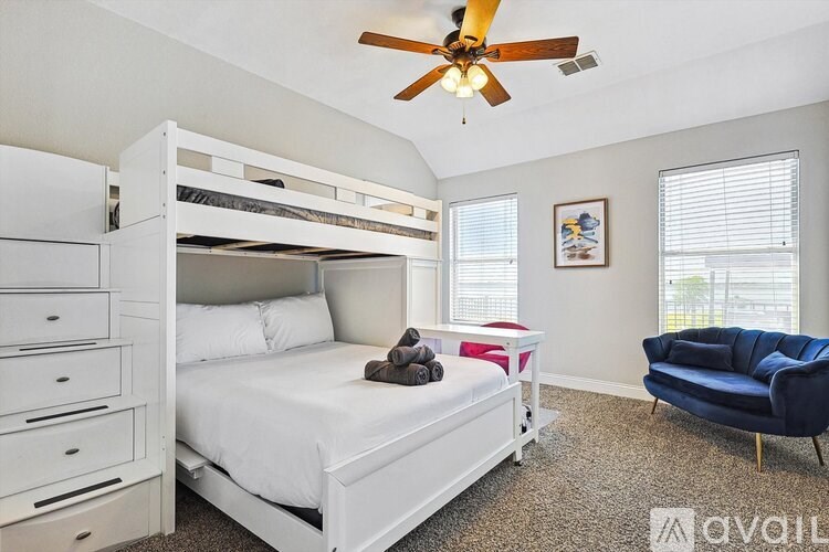 A bedroom with a white bed and a blue chair.