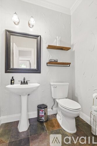 A bathroom with a white toilet and pedestal sink.