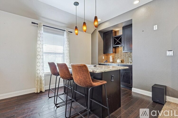 A kitchen with a bar area and chairs.