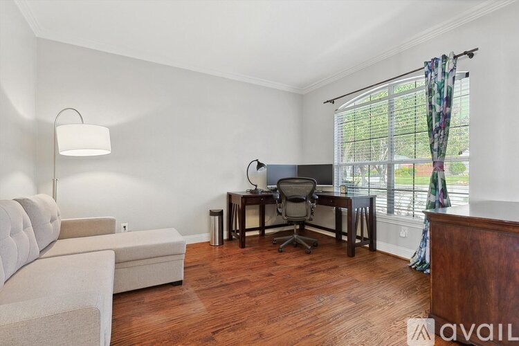 A room with a couch, desk, and chair.