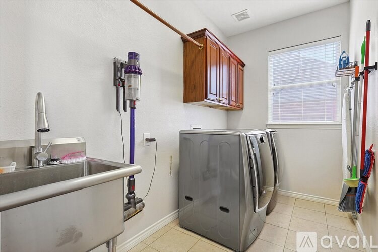 A clean, empty laundry room with a washer and dryer.