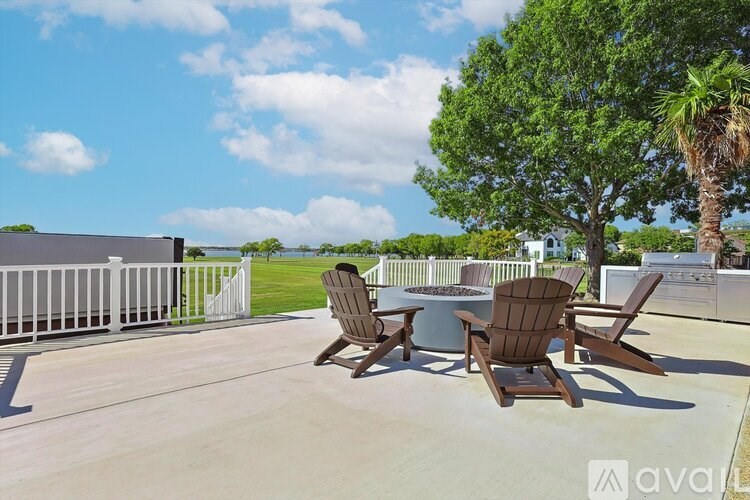 A patio with chairs and a table is set up on a sunny day.