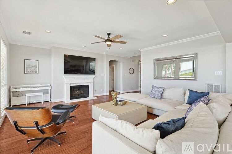A living room with a white couch and a fireplace.