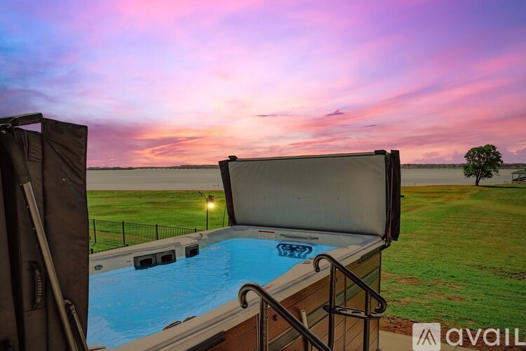 A hot tub is in the foreground with a beautiful sunset in the background.