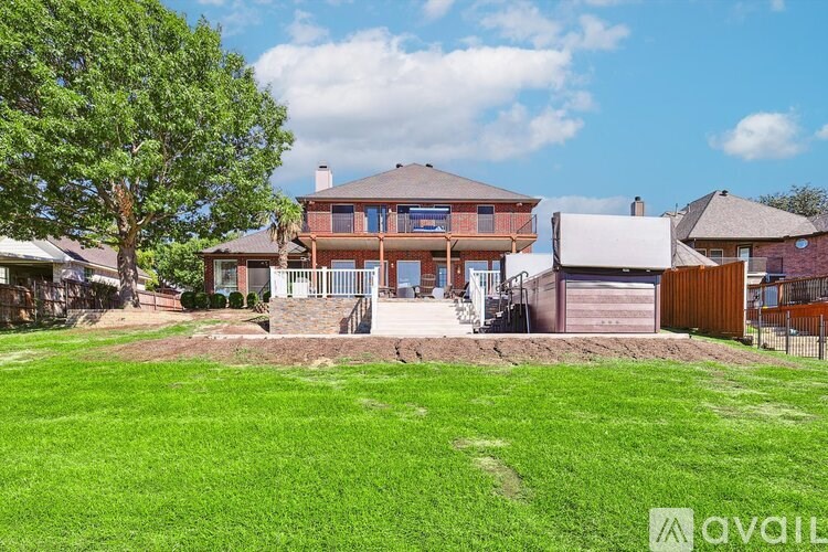 A house with a large front yard and a tree in the foreground.