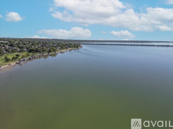 A large body of water with a small town on the left side and a bridge in the distance.