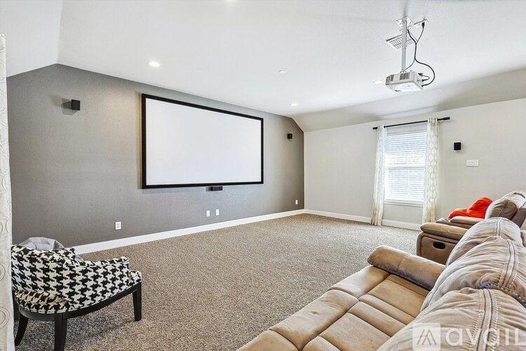 A living room with a black and white chair and a beige couch.