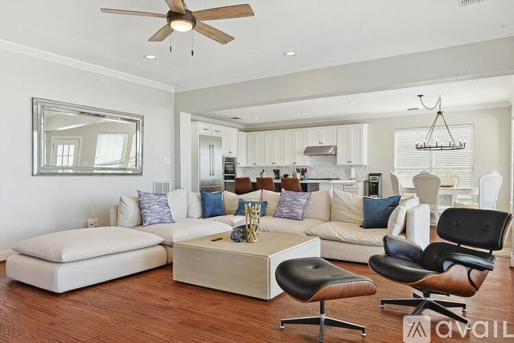 A living room with a white couch, a coffee table, and a ceiling fan.