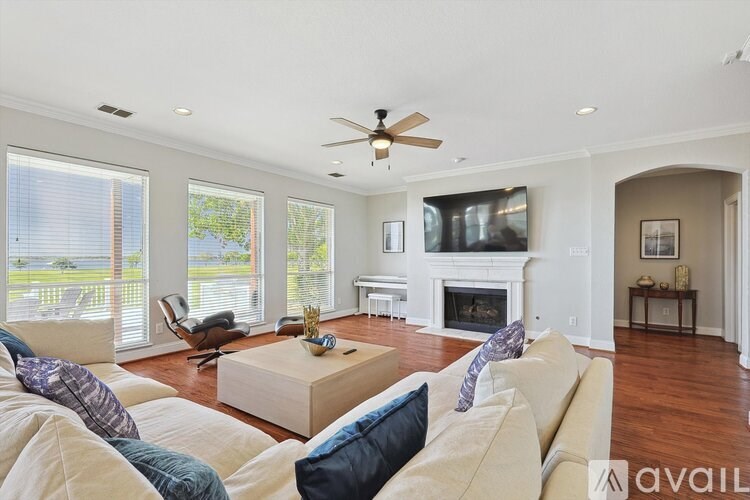 A living room with a beige couch and a fireplace.