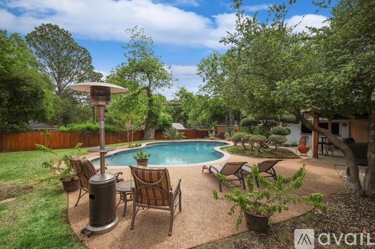 A backyard with a pool and patio furniture.
