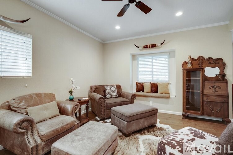 A living room with a brown leather couch and ottoman.