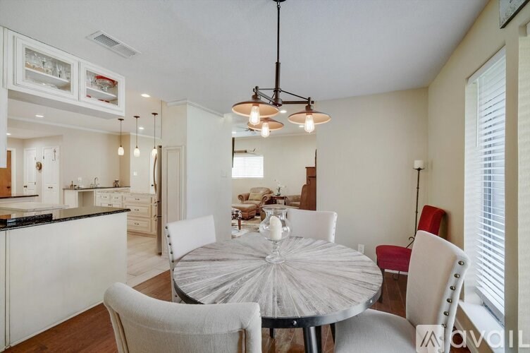 A modern dining room with a round table and chairs.