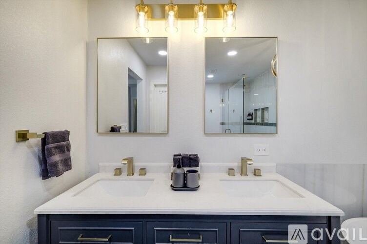 A bathroom with two sinks and a large mirror.