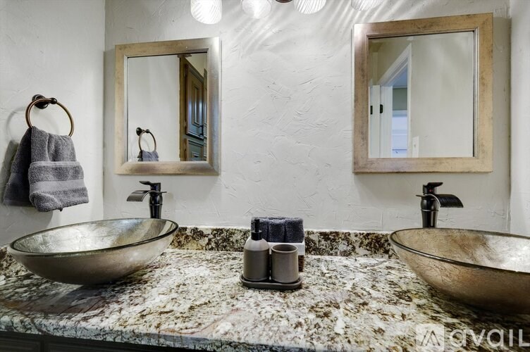 A bathroom with two sinks and a mirror above the counter.