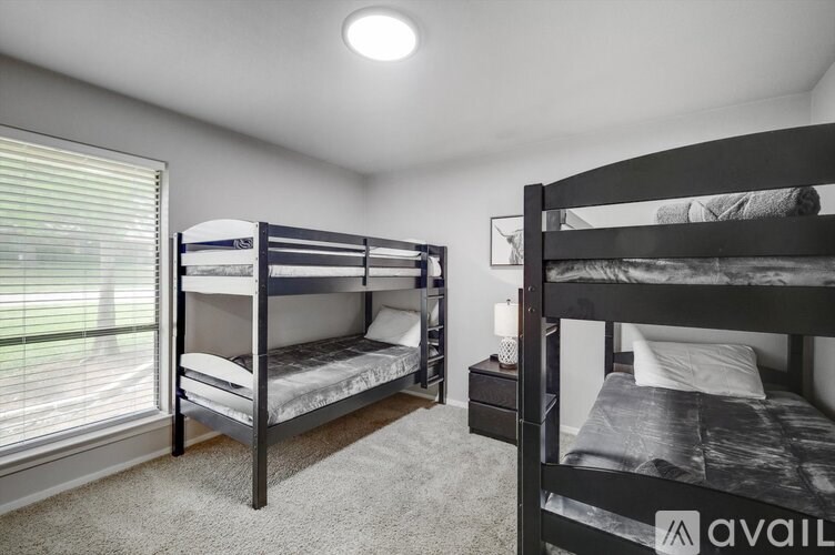 A bedroom with two bunk beds and a nightstand.