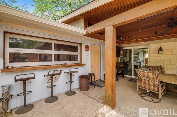A patio area with a table, chairs, and a bar.