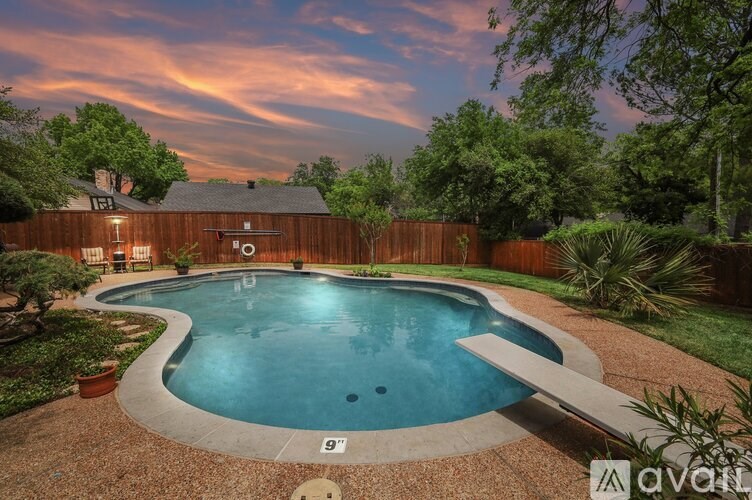 A backyard with a pool and a wooden fence.