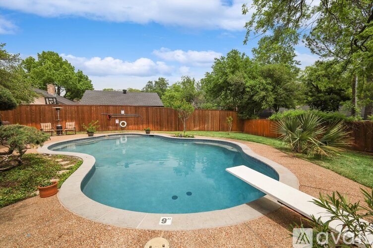 A small pool surrounded by a wooden fence and greenery.