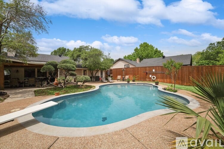 A backyard with a pool and a house.
