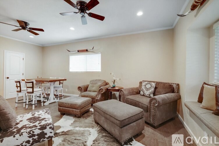 A living room with a cowhide rug and a variety of seating options.