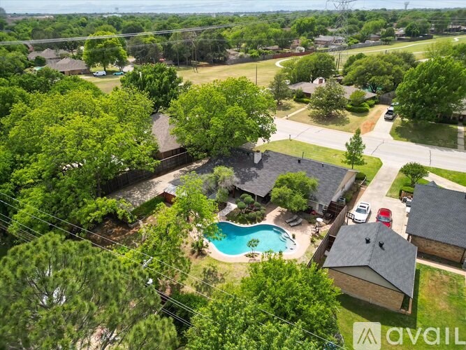 A bird's eye view of a neighborhood with a house and a pool.