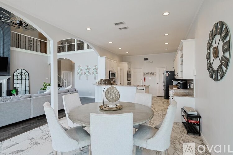 A modern dining room with a round table and chairs.