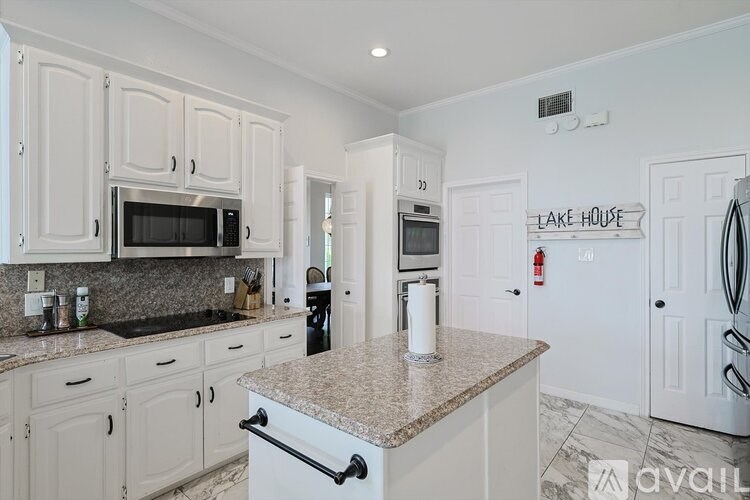 A kitchen with granite countertops and white cabinets.