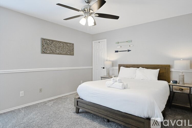 A bedroom with a bed, nightstand, and a ceiling fan.