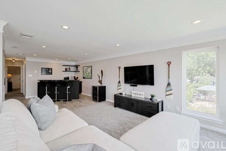 A living room with a white couch and a television.