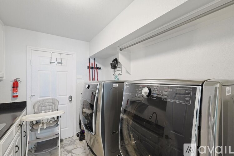 A kitchen with a white door and a white chair.
