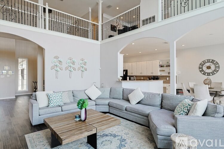 A living room with a grey couch and a wooden coffee table.