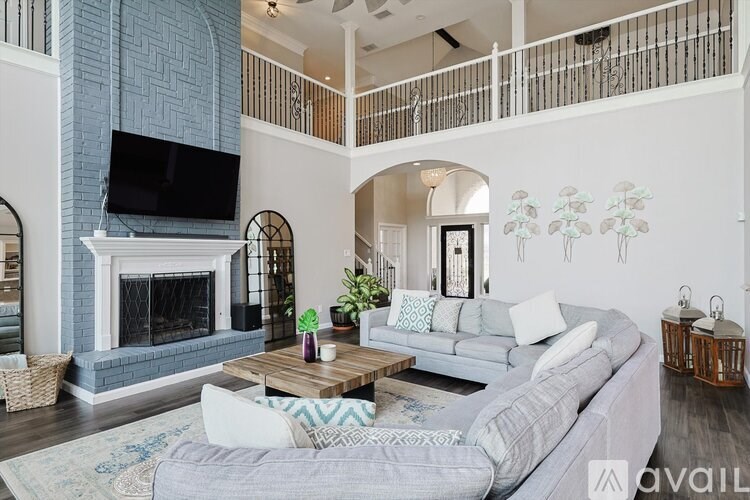 A living room with a grey couch and a fireplace.