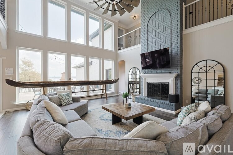 A living room with a grey couch and a fireplace.