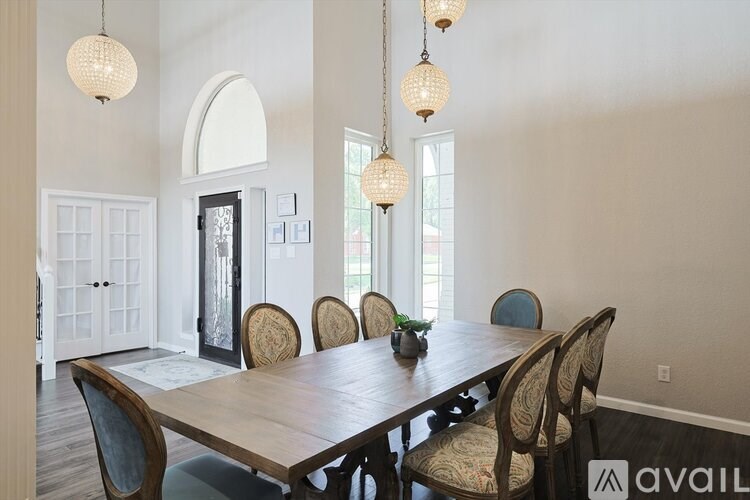 A dining room with a wooden table and chairs.
